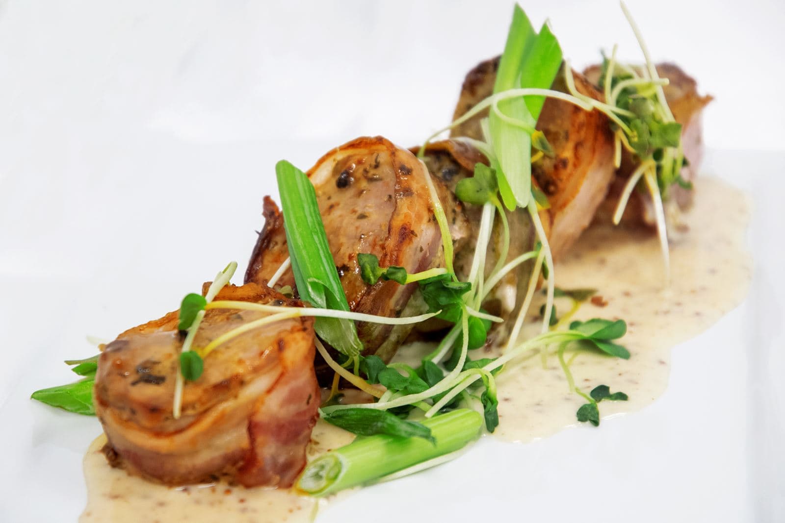 Pork tenderloin rolled in bacon with honey-mustard sauce